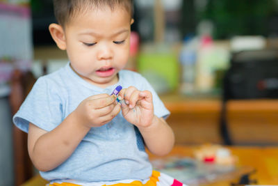 Boy with crayon on table at home