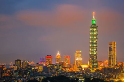 Illuminated buildings against sky at night