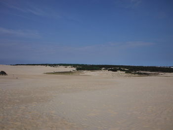 Scenic view of desert against blue sky