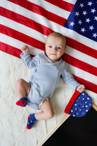 Top view of cute baby lying on usa flag