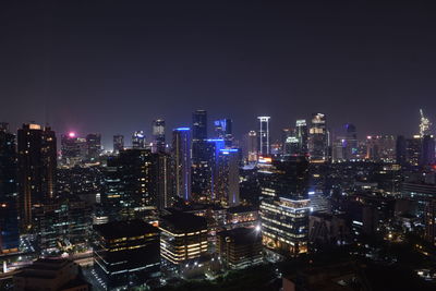 Illuminated cityscape against sky at night