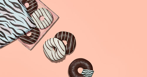 Close-up of person holding umbrella against orange background