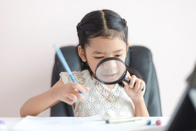 Portrait of a smiling girl holding table