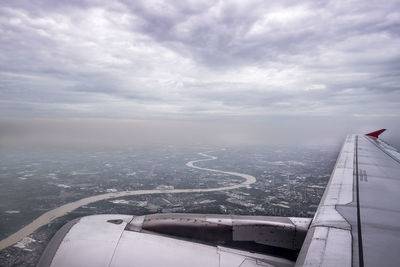 Aerial view of airplane wing against sky