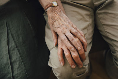 Midsection of couple holding hands