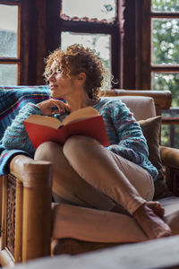 Young woman sitting on bed at home