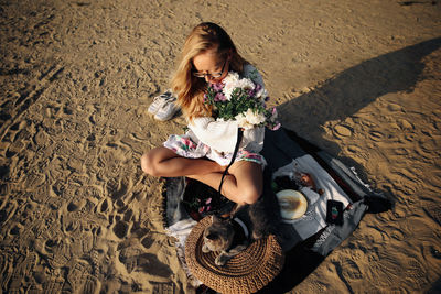 High angle view of woman sitting on sand