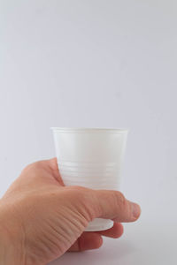 Midsection of person holding glass against white background