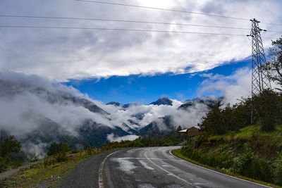 Road by mountains against sky