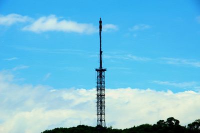 Low angle view of communications tower against blue sky