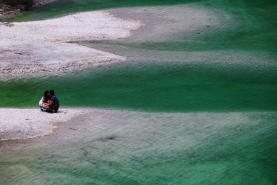 Couple sitting on shore at beach