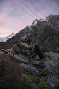 Hunter in mountains looking through binoculars