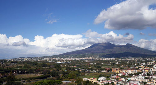Aerial view of townscape and mountains against sky