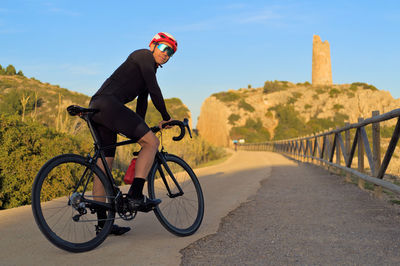 Cyclist standing on the road looking at the camera.