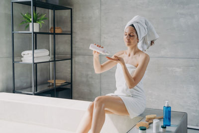 Side view of mother and daughter standing in bathroom