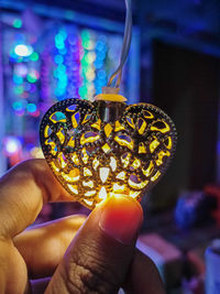 Close-up of hand holding illuminated lamp