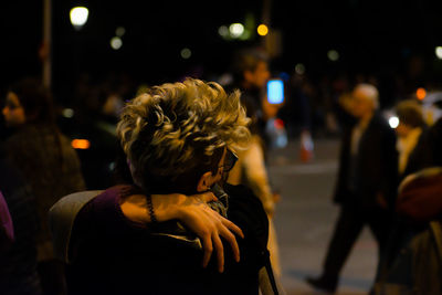 Rear view of people on street at night