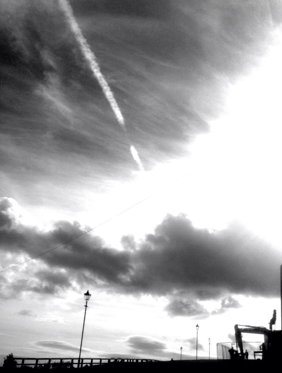 low angle view, sky, cloud - sky, street light, built structure, cloudy, sunbeam, silhouette, building exterior, architecture, sunlight, cloud, sun, nature, outdoors, weather, no people, day, beauty in nature, overcast