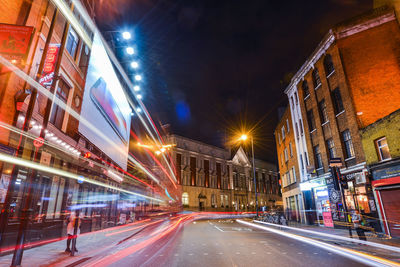 Light trails on road along buildings at night