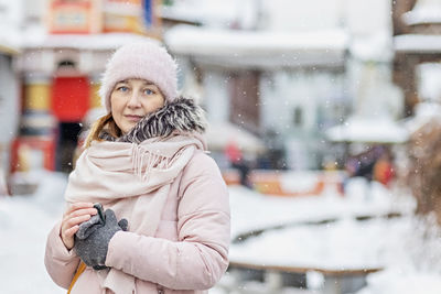 Portrait of a young woman in warm winter clothes outdoors while traveling. winter time, snow.