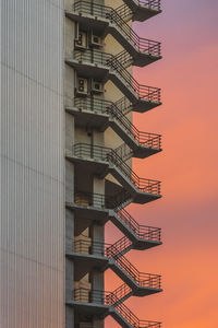 Emergency exit of building against sky during sunset