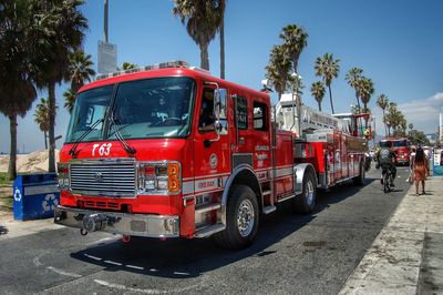 Red truck on road in city against sky