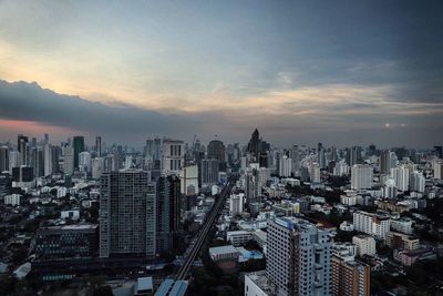 Aerial view of cityscape against cloudy sky