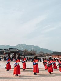 Rear view of people on beach against sky