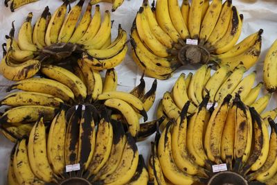 High angle view of fresh banana bunches with labels at market stall