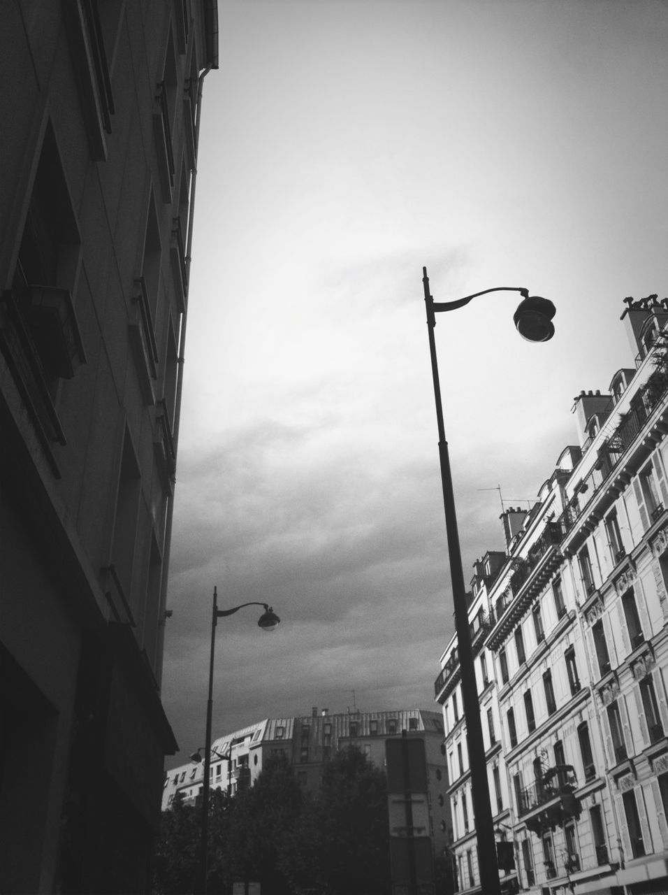 architecture, building exterior, built structure, low angle view, street light, sky, city, building, residential building, residential structure, lighting equipment, window, cloud - sky, city life, outdoors, cloud, dusk, day, no people, office building