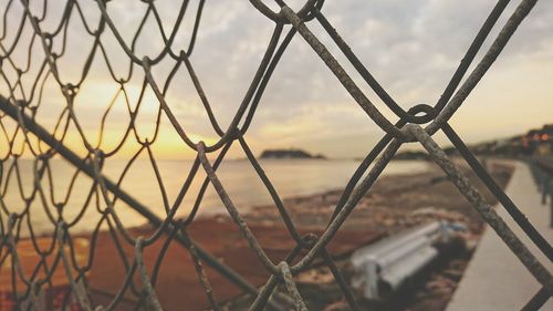 Close-up of chainlink fence against sky