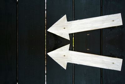 High angle view of arrow symbol on boardwalk