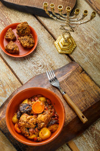 Jewish dish shut with meat on a wooden table near matzo and ingredients. vertical photo