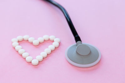 High angle view of heart shape on pink over white background