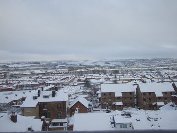 Houses in town against sky during winter