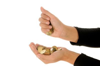 Close-up of hand holding chocolate over white background