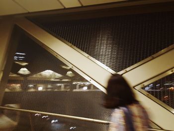 Blurred motion of people walking on illuminated railroad station