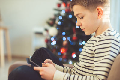 Boy using digital tablet at home during christmas