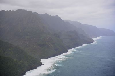 Scenic view of sea and mountains against sky