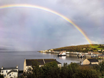 Scenic view of rainbow over city against sky