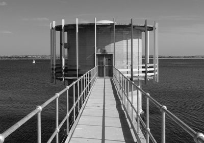 Built structure by river against sky