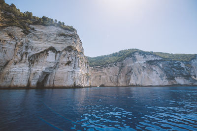 Scenic view of sea and mountains against clear sky