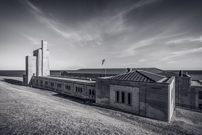 Built structure by sea against sky