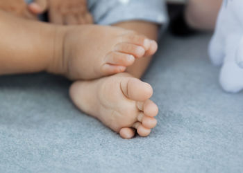 Cropped image of baby on bed