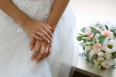 Midsection of bride holding bouquet