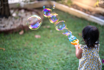 Full length of woman holding bubbles