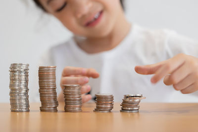 Midsection of woman stacking coins on table