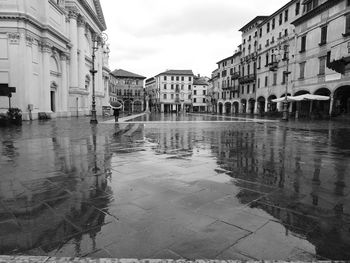 Reflection of buildings on wet street during rainy season