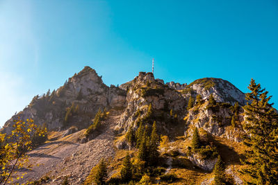 Low angle view of rock formation against clear blue sky