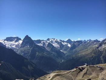 Scenic view of snowcapped mountains against clear blue sky